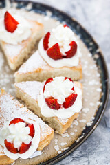 Pieces of White Angel cake, decorated with whipped cream and fresh strawberries