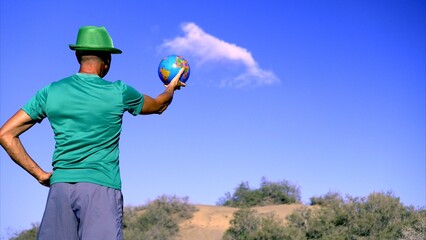 Saving the planet from global warming, a young activist in a desert environment holds up the globe...