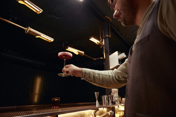 Satisfied bartender feeling excited to prepare best bar cocktail