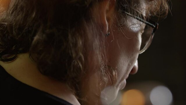 Woman in glasses stands in a workroom with light flares