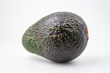 A single, whole avocado with its dark green skin, placed centrally on a white background.