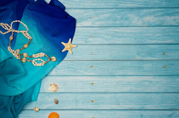 Beach accessories with shells on a blue wooden background. Top view, copy space