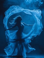 A woman dances with a blue cloth flowing around her body. - obrazy, fototapety, plakaty