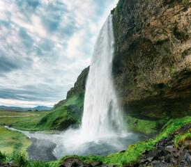 Moody of Seljalandsfoss waterfall flowing in summer at Iceland