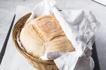 Overhead view of homemade artisan bread in a brown basket, top view of baked sourdough artisan...