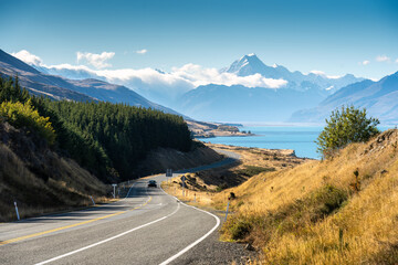 Scenic road trip of Mt Cook over winding road and Lake Pukaki on sunny day at New Zealand