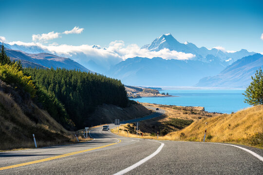 Scenic road trip of Mt Cook over winding road and Lake Pukaki on sunny day at New Zealand