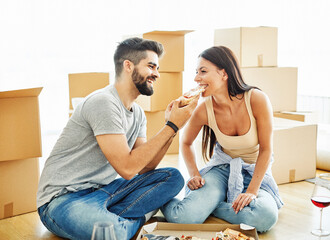 woman couple man box home house moving happy apartment together romantic relocation pizza eating - obrazy, fototapety, plakaty