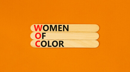 WOC women of color symbol. Concept words WOC women of color on beautiful wooden stick. Beautiful orange background. Business WOC women of color social issues concept. Copy space. - obrazy, fototapety, plakaty