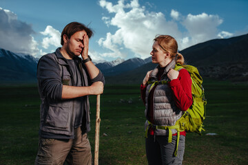 Young couple of hikers debate in the mountains