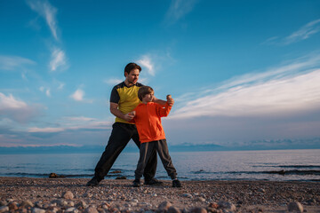 Father and son training on the lake shore