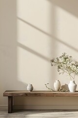 A large wall with an empty space, a wooden table on the right side of it, a white ceramic vase and plants in vases next to each other on top of that, a beige solid color background, simple style