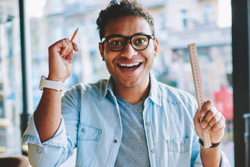 Half length portrait of smiling intelligent hindu male architect exciting about good idea for...