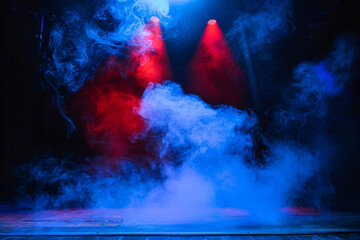 A stage with thick powder blue smoke illuminated by a bright red spotlight, providing a cool, dramatic visual.