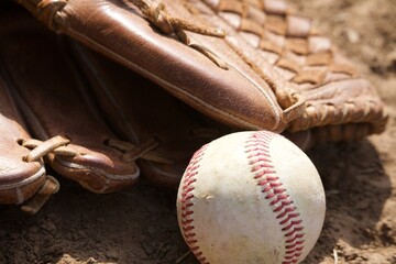 baseball and glove in the dirt