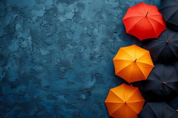 Striking visual contrast with bright orange umbrellas against a textured blue wall backdrop