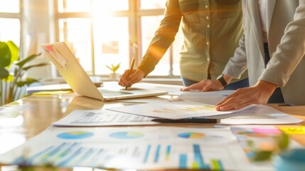 Close-up of a business strategy session with documents and digital tools, highlighting teamwork and planning.