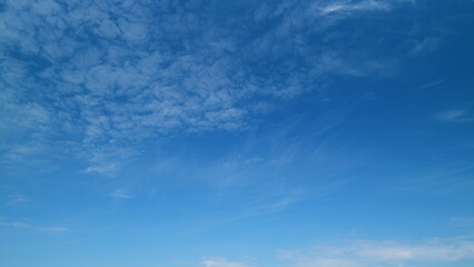 Background of clouds and sky on a sunny day. Light blue and white colours of real skies with...