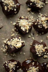 Hazelnut-date confectionery, vegan, very creamy, covered with dark chocolate with coconut blossom sugar and chopped hazelnuts