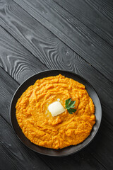 delicious mashed sweet potatoes on a black wooden rustic background