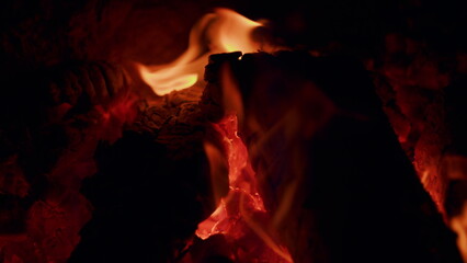 Natural wood log fire embers glowing great for background. Slow motion burning bonfire. Close up.