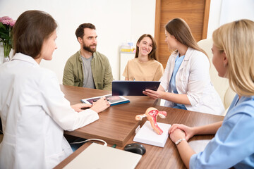 Obraz premium Medical meeting reviewing results of examining young pregnant caucasian woma