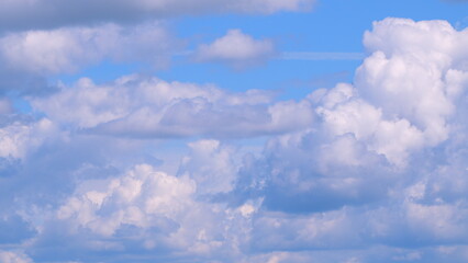 Dramatic moving white cumulus and cirrocumulus clouds or puffy fluffy cloudscape on beautiful sunny...