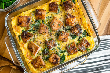 Omelette with pork and spinach in a glass baking dish.