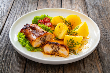Baked rabbit saddle and vegetable salad on wooden table
