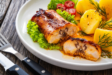 Baked rabbit saddle and vegetable salad on wooden table
