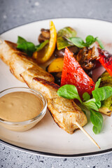 barbecue chicken and vegetables on a white plate