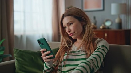 Disappointed woman reading cellphone message in apartment living room close up. - Powered by Adobe