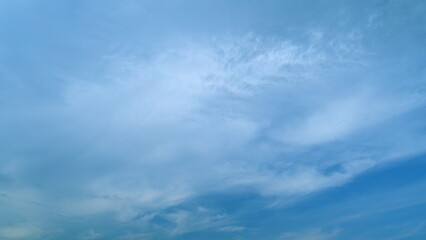 Flying moving white clouds in a blue sky. Blue sky background with many layers tiny clouds. Timelapse.