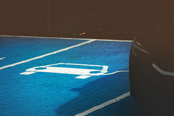 electric car parking and charging bay with parked electric vehicle. blue painted cobblestone and...