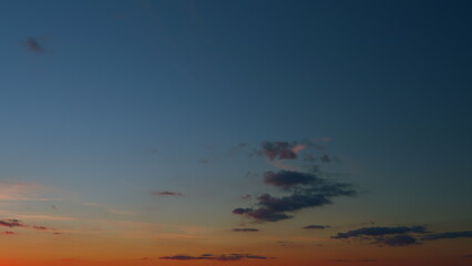 Panoramic view. Sunset sky with condensation trail. Dramatic warm near and far clouds at sunset....