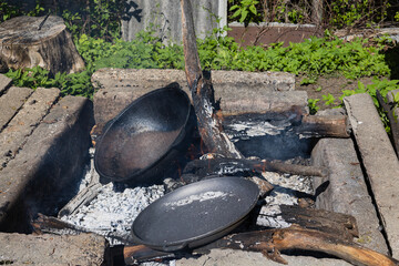 Firing cast iron pasta over a fire. Processing cast iron at the stake