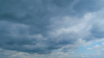 Cumulus clouds moves in the blue sky. Dark huge cloud in sky. Change of weather. Time lapse.