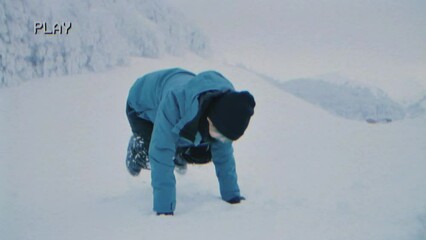 Fake VHS capture: on a cold winter day, a joyful kid eagerly prepares to throw snowballs at friends and family for fun.
