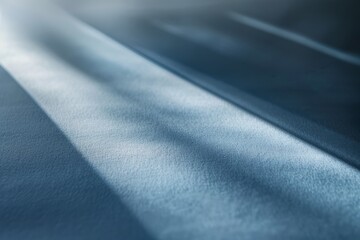 Close-up shot of a light blue fabric with a blurred effect, capturing the play of light and shadow on the smooth surface