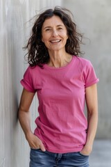Fototapeta premium happy european 50 years old woman wearing a regular brand new plain bright-pink-colour t-shirt, she is happy,