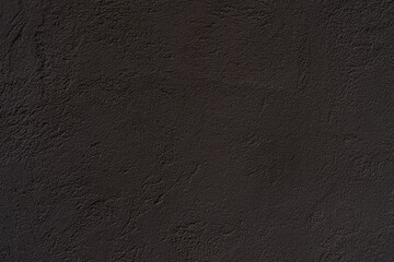 Texture of an old black plastered wall. Abstract construction background.