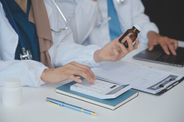 Asian psychologist women pointing on pills bottle to explaining medicine and prescription to female...