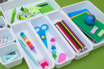 School supplies.Concept back to school. colored stationery is arranged in white organizers. Creative Drawer Organizing. Storage office supplies.