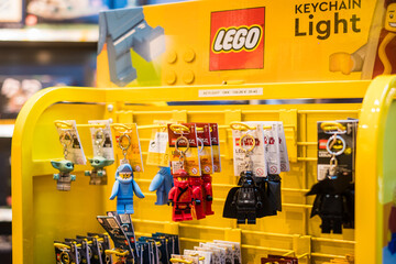 Naklejka premium Copenhagen, Denmark - April 7, 2024: Lego keyrings Lego brand shop in Copenhagen Airport. Legos are interlocking plastic bricks.