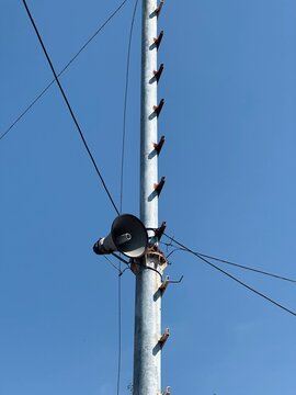 A lone metal pole stands tall against a clear blue sky