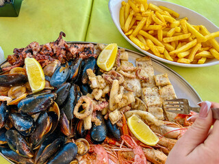 Seafood platter with musselspus, squid, squidpus and French fries a Marsaxlokk cafe, Malta