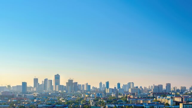 A wide panoramic view of a sprawling city skyline under a clear blue sky symbolizes growth and development