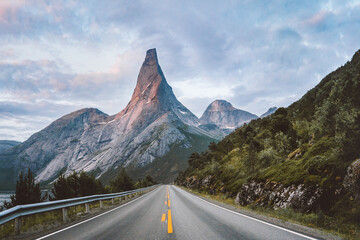 Stetind national mountain and empty asphalt road in Norway sunset rocky peak landscape, summer...