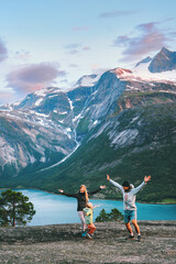 Family travel lifestyle - parents playing with child outdoor in Norway - mother, father and kid daughter on summer vacations hiking trip in Norway fjord and mountains sunset landscape