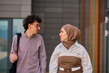 After a day at the office, a business man engages in conversation with his Muslim colleague wearing a hijab